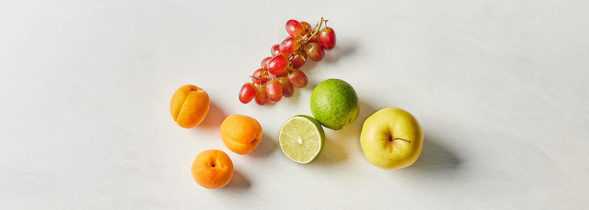 aprikos, druer, lime og gult eple