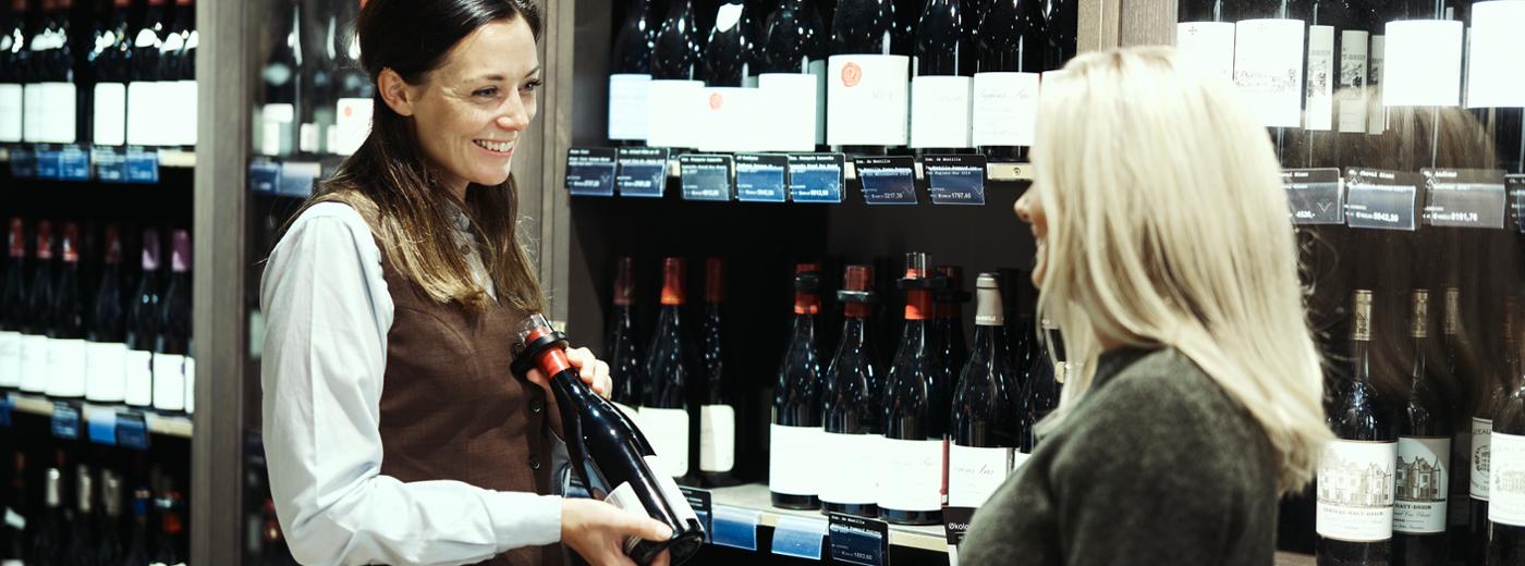 Ansatt gir råd om vin til kunde.