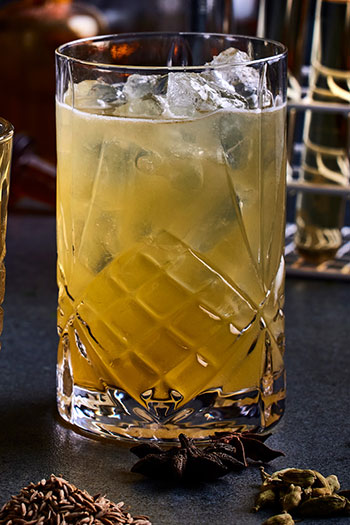 Lys brun drink i et glass med isbiter.