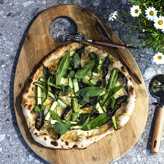 bord med trefjøl og pizza med ramsløk og asparges